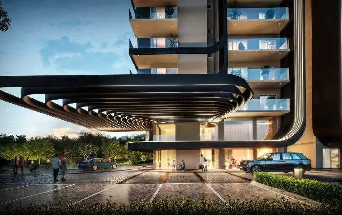Dusk render of Smartworld Newly Launched Sector 67's sculptural black ribbed entrance canopy beneath illuminated residential balconies, with luxury cars including a Rolls-Royce parked at the porch and residents walking through the landscaped entrance.
