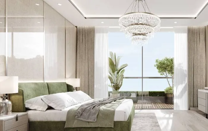 Interior render of a master bedroom at Smartworld New Launch in Sector 67 with a sage-green upholstered bed, layered white and grey bedding, a tiered crystal chandelier, sheer curtains, and a glass door opening onto a private balcony with potted plants.